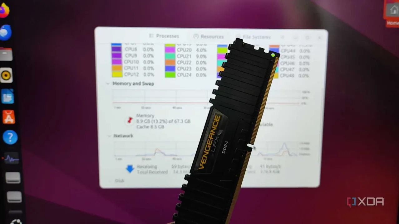 A person holding a USB stick in front of a monitor running Ubuntu from the RAM