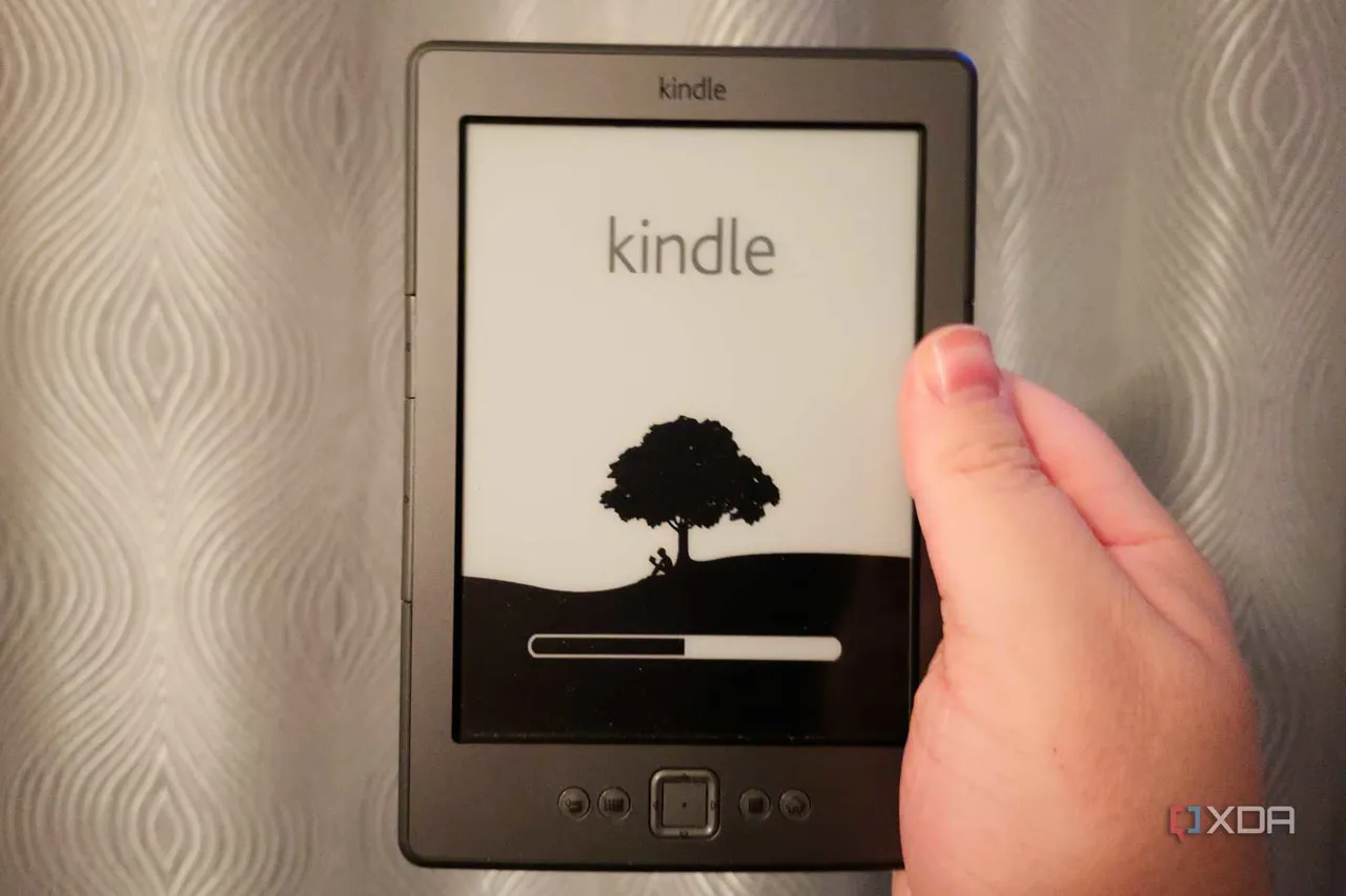 Beyaz arka plan önünde tutulan Amazon Kindle 4. nesil cihaz
