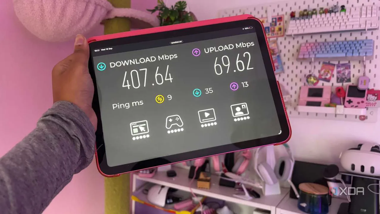 Pembe arka plan önünde tutulan tablette internet hız testi